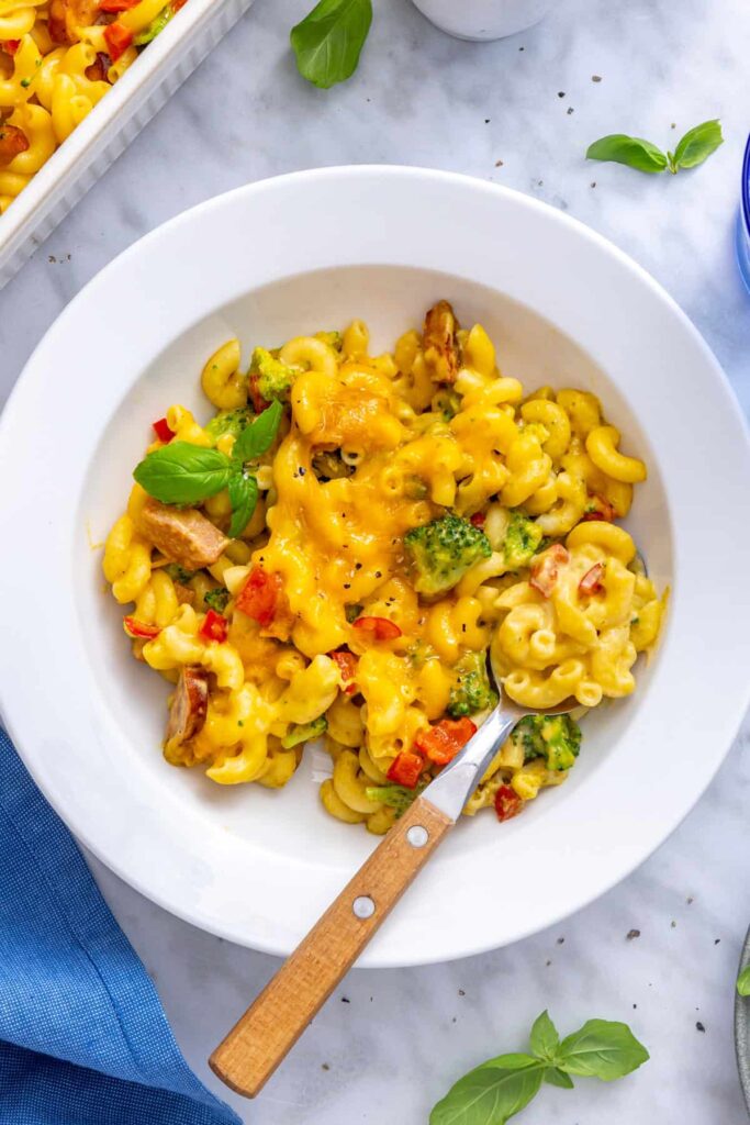 Overhead bowl of creamy broccoli cheddar pasta with broccoli and chicken sausage