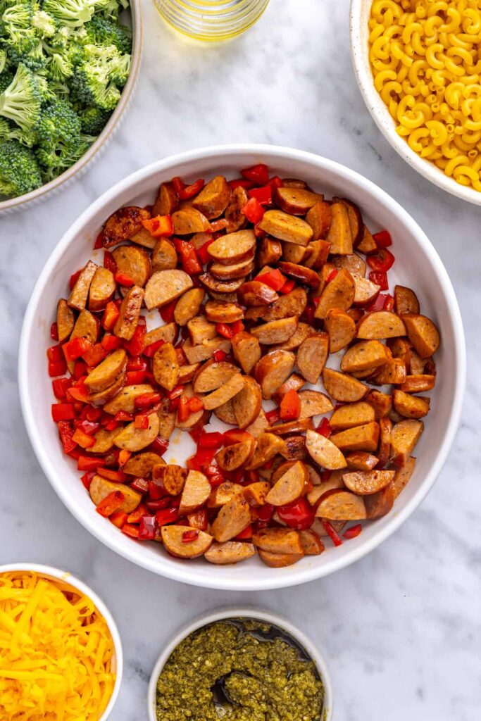 Golden browned chicken sausage with tender red bell pepper for broccoli cheddar pasta
