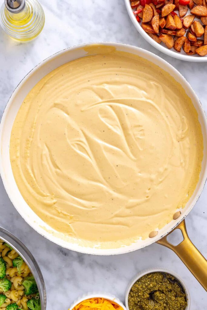 Blended cottage cheese cheddar sauce poured into a skillet to thicken
