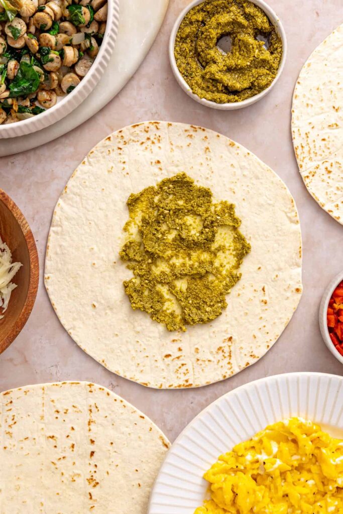 Basil pesto spread down the center of a burrito-size tortilla