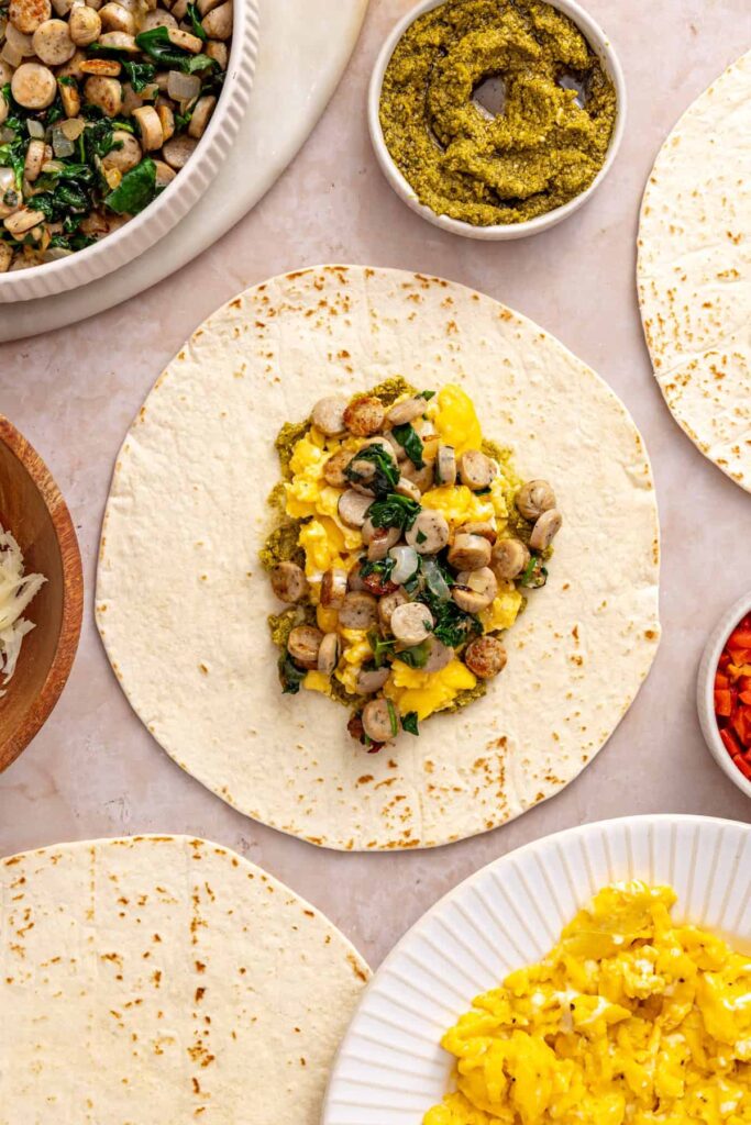 Eggs, chicken sausage and spinach filling layered over pesto for a breakfast burrito