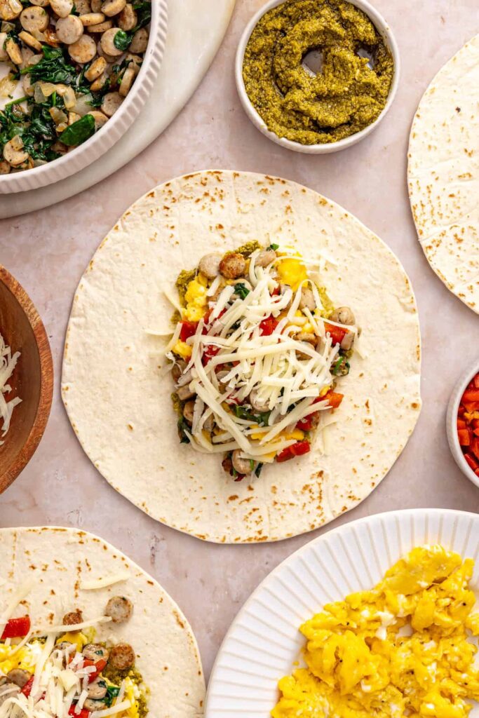 Mozzarella sprinkled over eggs, chicken sausage, spinach and roasted red peppers in a tortilla
