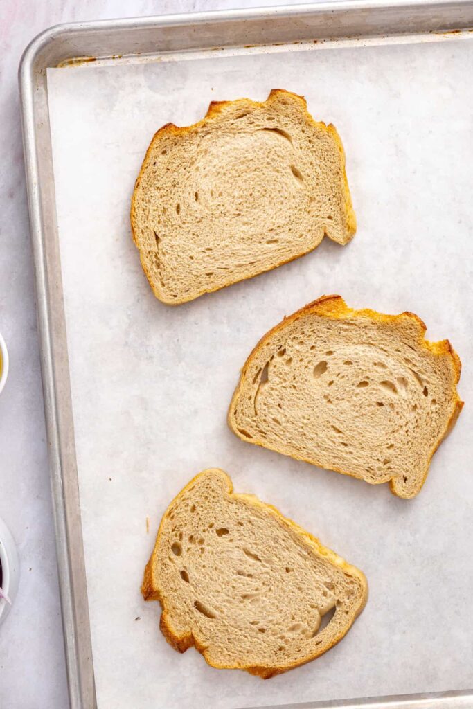 Sourdough bread slices ready to be toasted for homemade crispy chicken cutlet breadcrumbs.