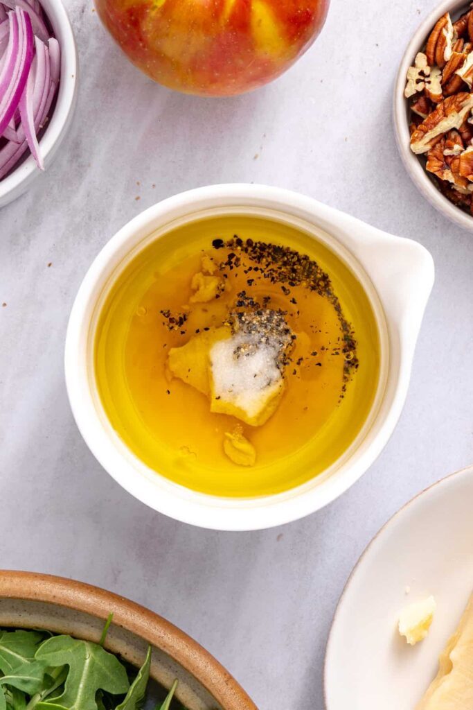 Maple Dijon vinaigrette made with olive oil, apple cider vinegar, Dijon mustard, maple syrup, salt, and pepper.