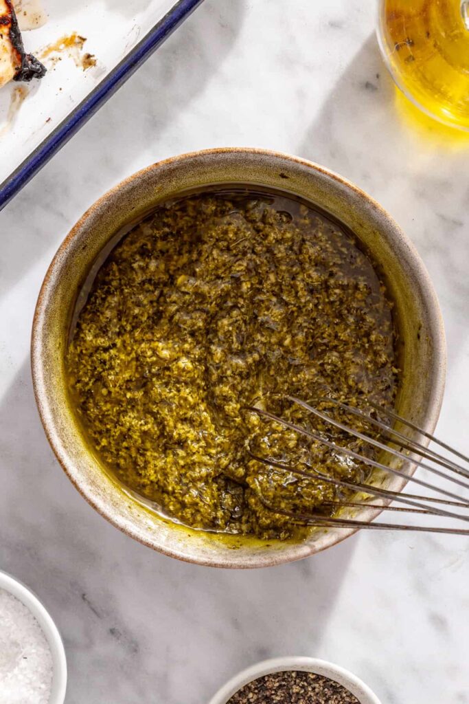 whisking olive oil and pesto together into a simple pesto dressing