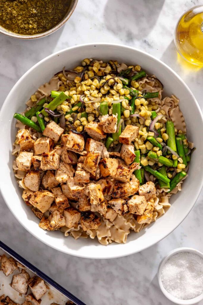 Pasta, grilled vegetables and sliced chicken combined in a large serving bowl