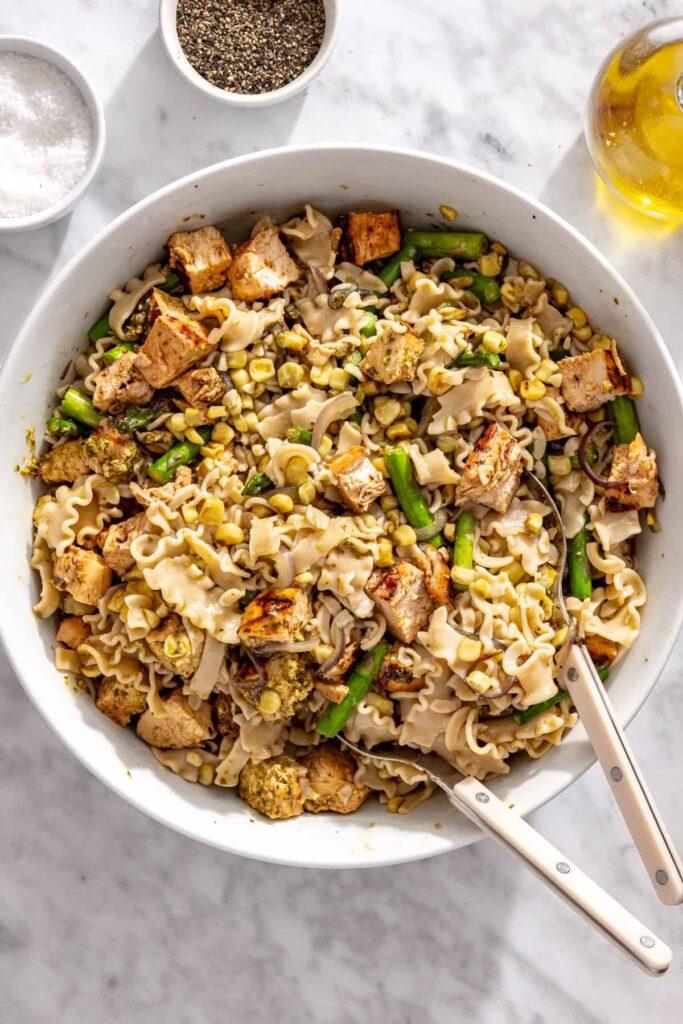 Chicken pesto pasta salad tossed with grilled vegetables and pesto dressing