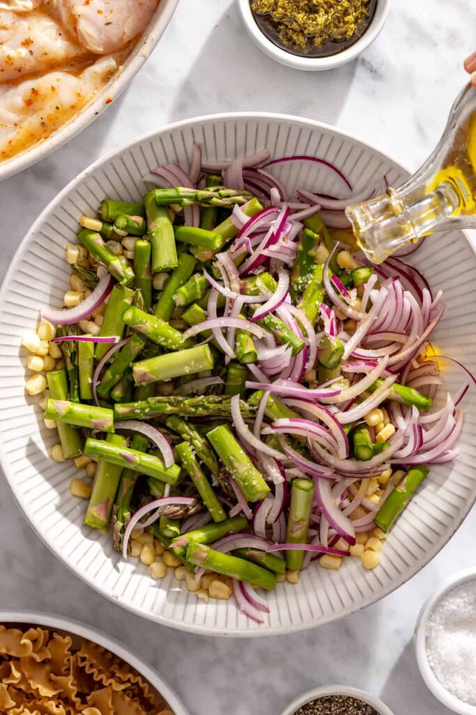 Asparagus, corn and red onion seasoned with olive oil and sea salt for grilling