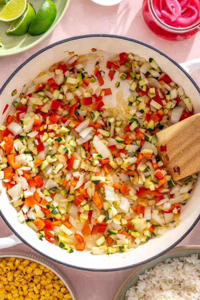 Sautéed onion, bell pepper, and zucchini softened and lightly browned in a skillet