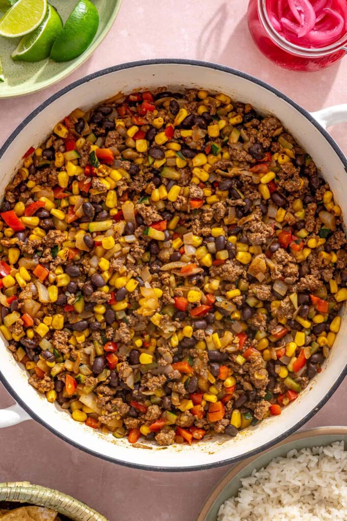 Fire-roasted corn and black beans stirred into seasoned ground beef and vegetables