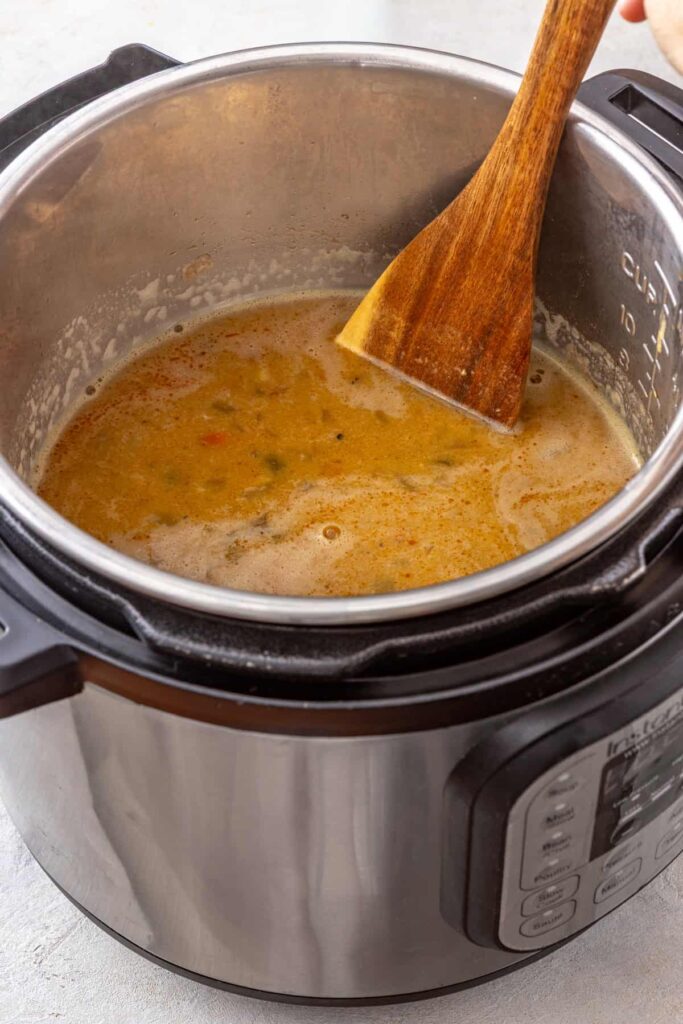 stirring the blended base of a buffalo chicken chili before adding the shredded chicken back in to the Instant Pot