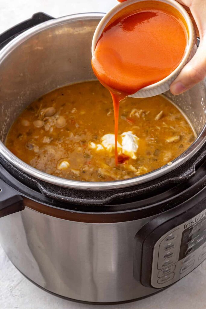 Buffalo hot sauce stirred into Instant Pot chicken chili