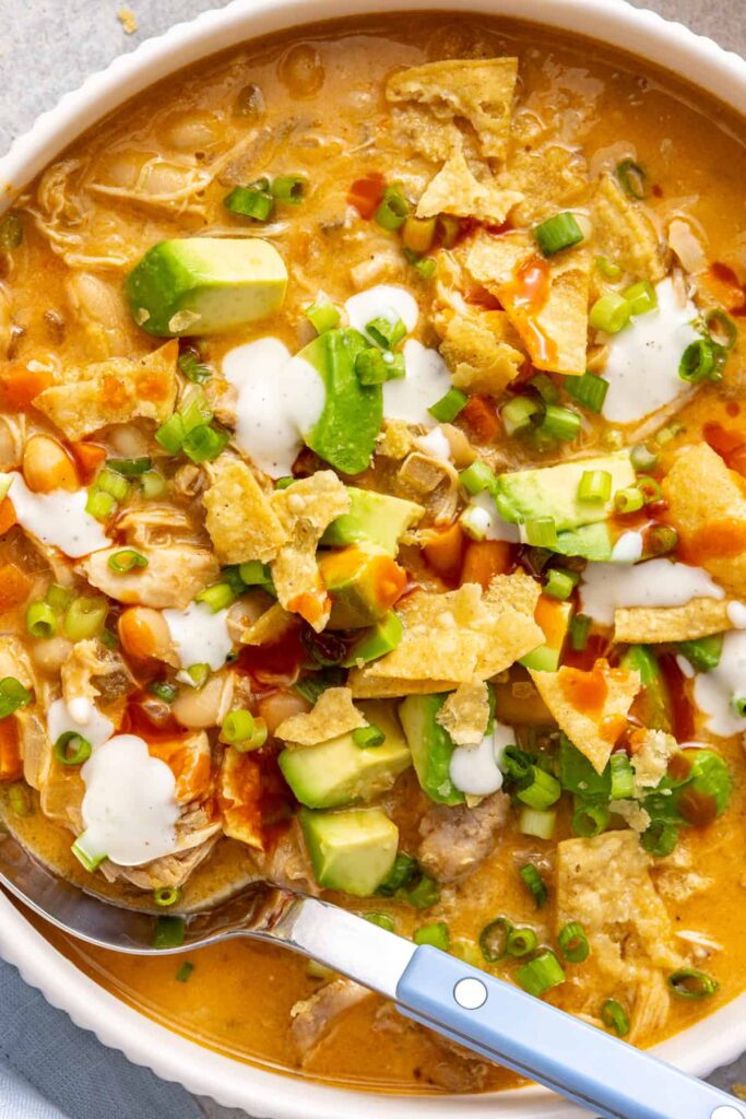 Buffalo chicken chili topped with avocado, green onion, ranch and buffalo sauce