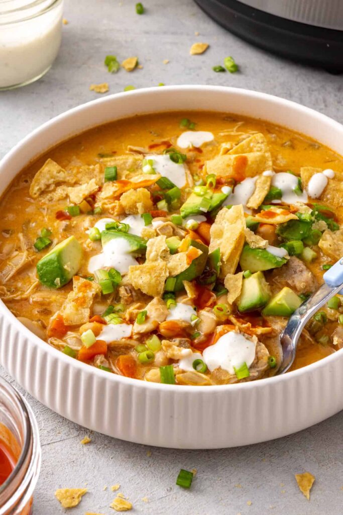 Garnished bowl of Instant Pot buffalo chicken chili served with a spoon