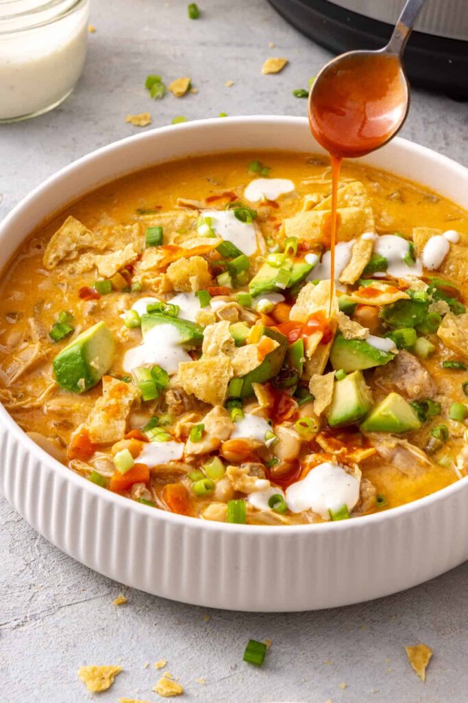 Buffalo chicken chili topped with an extra drizzle of buffalo hot sauce