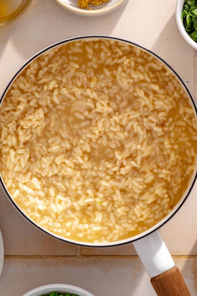 Arborio rice simmering in chicken bone broth until creamy