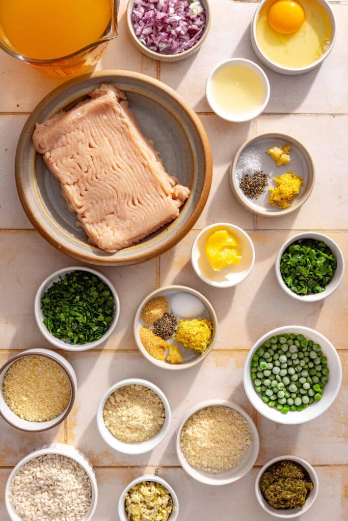 Ingredients for lemon artichoke chicken meatballs and creamy parmesan rice arranged on a table