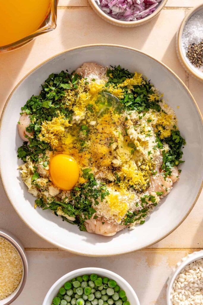 Ground chicken meatball mixture with artichoke hearts, pesto, lemon zest, herbs and parmesan