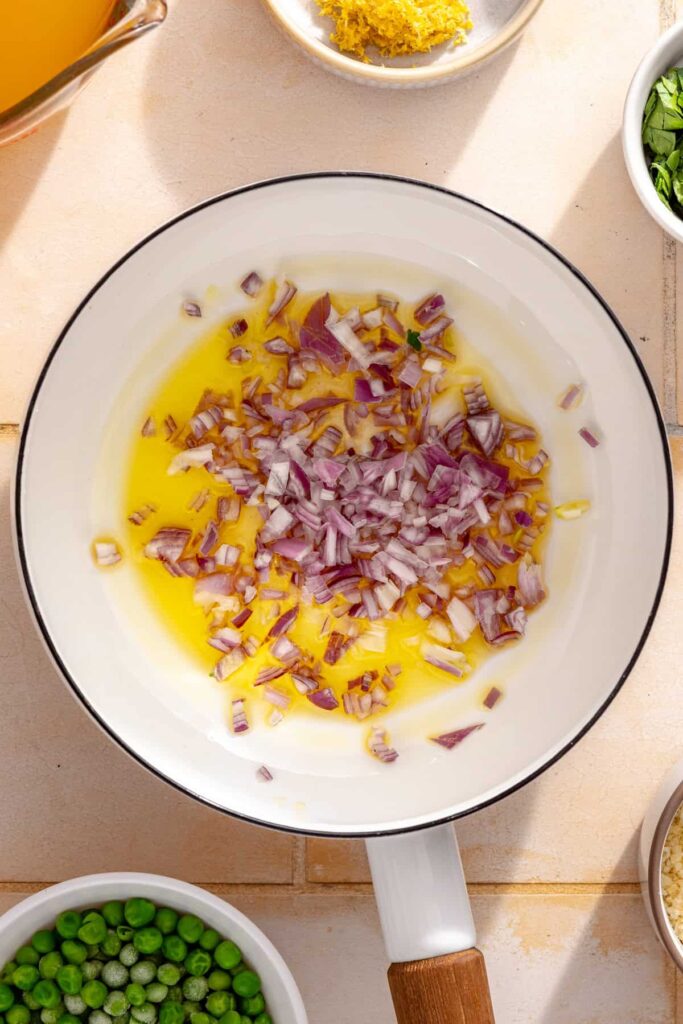 Diced shallot cooking in olive oil for creamy parmesan rice