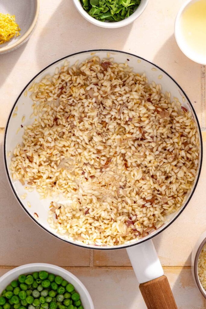 Minced garlic cooking with shallot for creamy parmesan rice