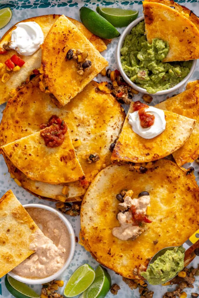 Golden quesadilla wedges served with guacamole, lime and extra taco filling