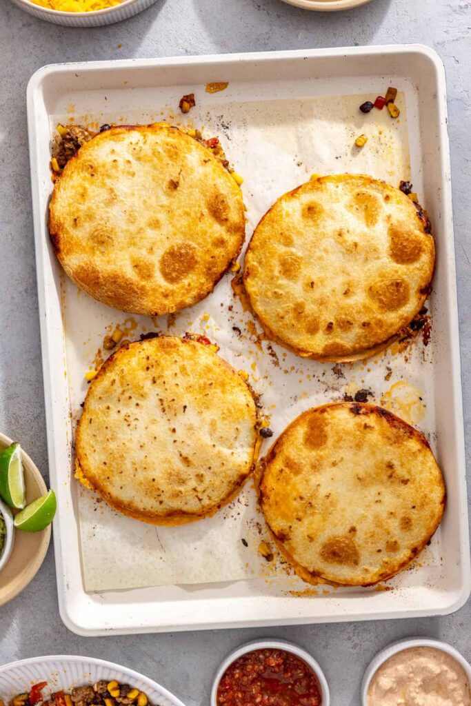 Crispy sheet pan quesadillas cooling on the baking pan before serving