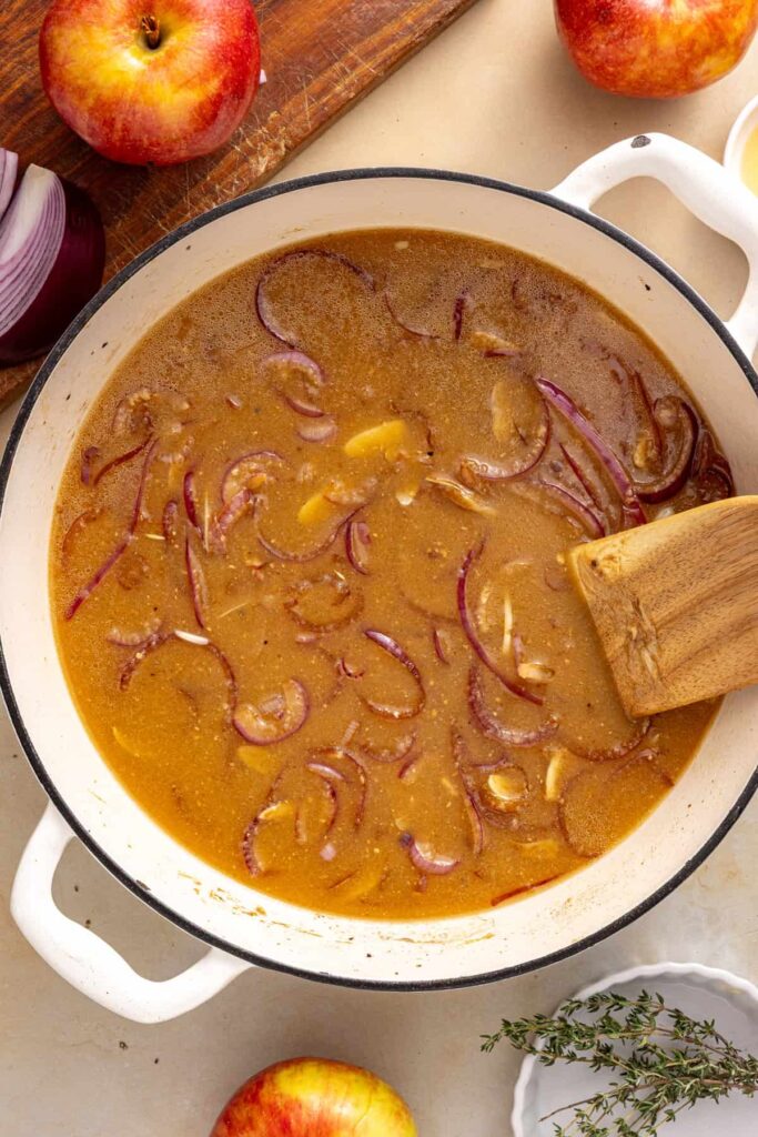 Apple cider gravy base whisked together in a skillet with Dijon mustard and applesauce.