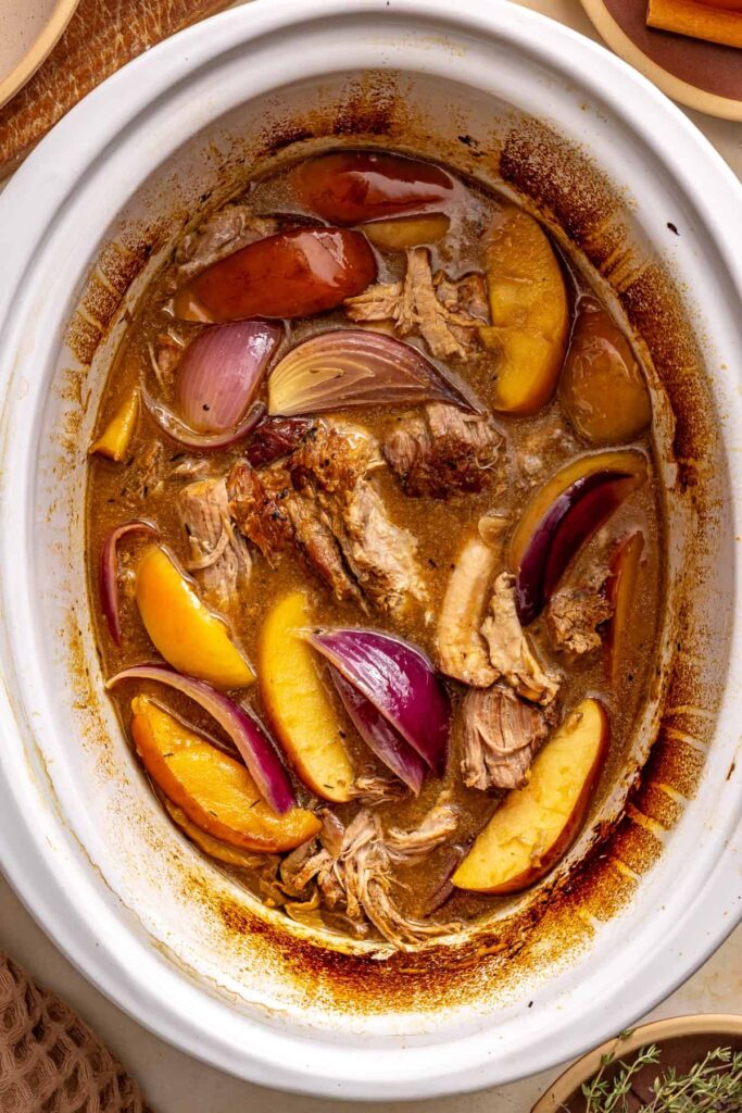 Shredded pork, tender apple wedges, and red onion coated in glossy apple cider gravy in the slow cooker.