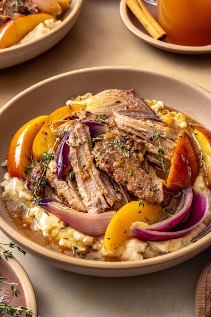 Shredded pork shoulder with apple wedges and savory cider gravy served over creamy mashed potatoes.