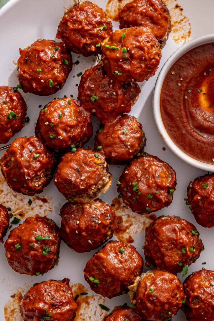 Close-up overhead view of glossy BBQ beef meatballs coated in a thick barbecue glaze.