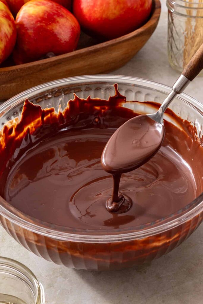 Dark chocolate chips melting with coconut oil for coating a date caramel apple