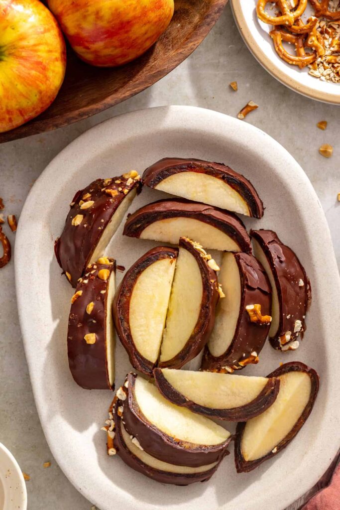Overhead view of date caramel apple slices with chocolate, nut and pretzel toppings