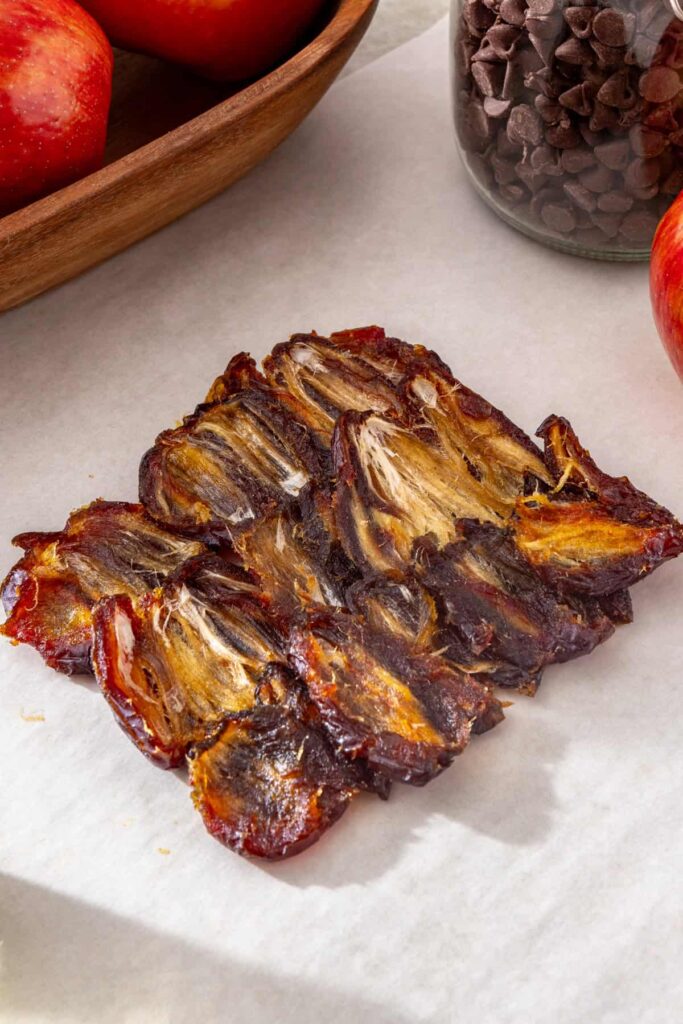 Pitted dates arranged side-by-side on parchment paper to make the date caramel layer
