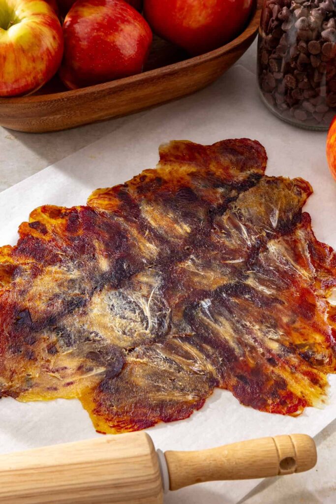 Pitted dates rolled into a thin layer between sheets of parchment paper