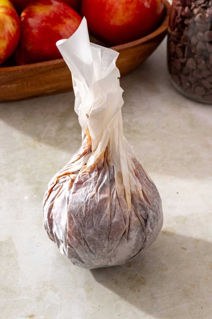 Date layer being wrapped tightly around an apple to make a date caramel apple