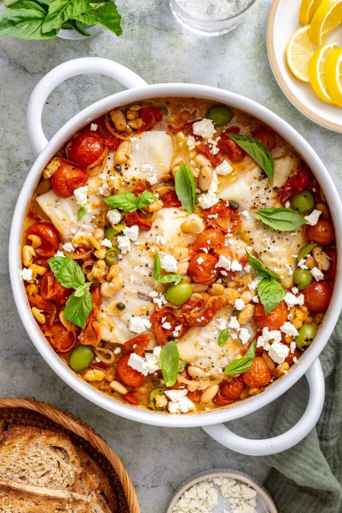 Finished cod skillet topped with crumbled feta, fresh basil, and a squeeze of lemon.