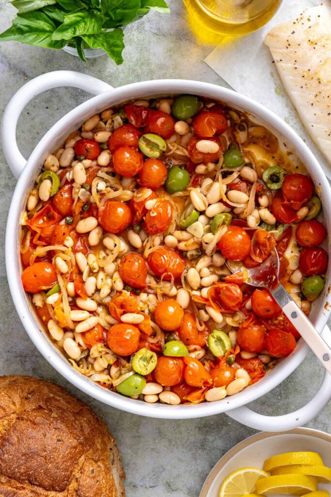 Preparing the Mediterranean tomato sauce with cannellini beans, green olives, capers, and lemon zest.