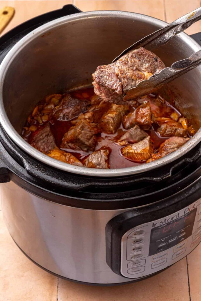 Beef taco filling pressure cooking in the Instant Pot until tender enough to shred.