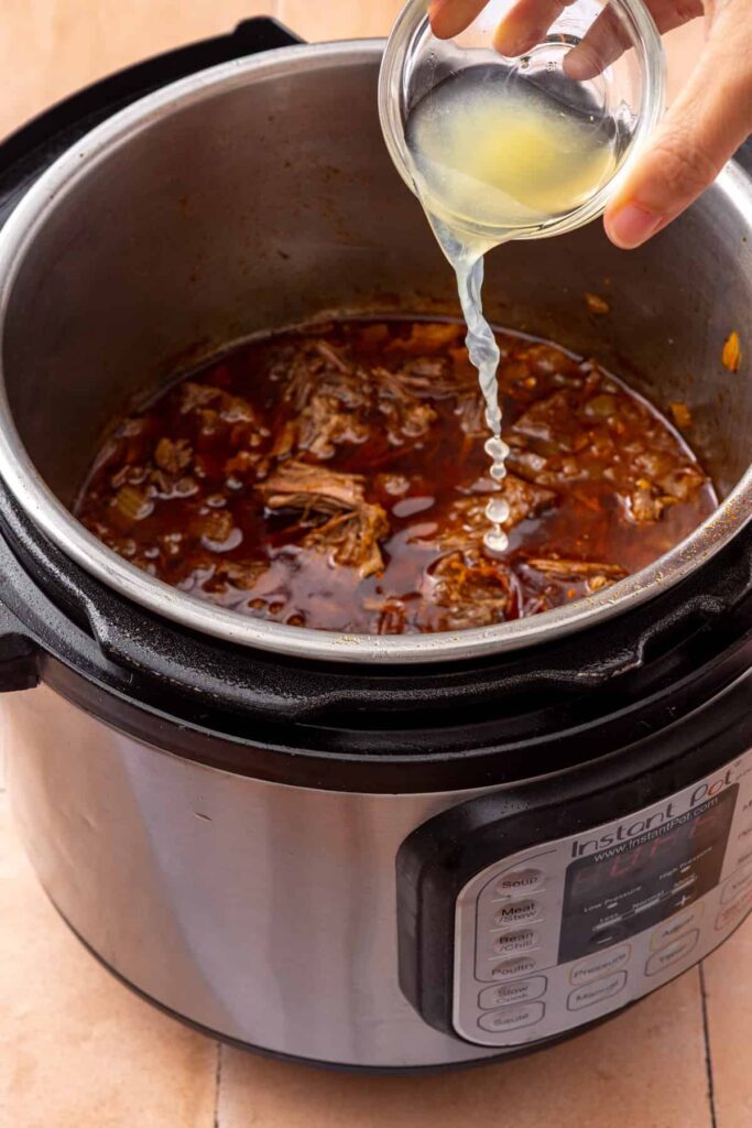 Fresh lime juice added to shredded Instant Pot taco beef to brighten the flavor.