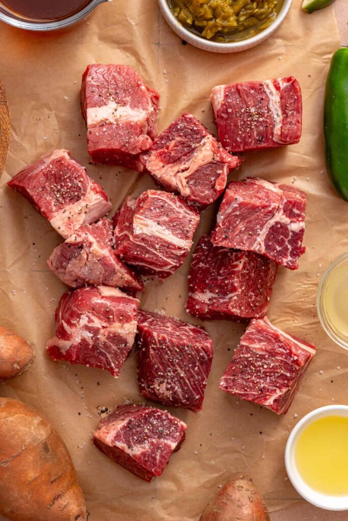 Beef chuck roast chunks seasoned with kosher salt and black pepper for Instant Pot taco beef.