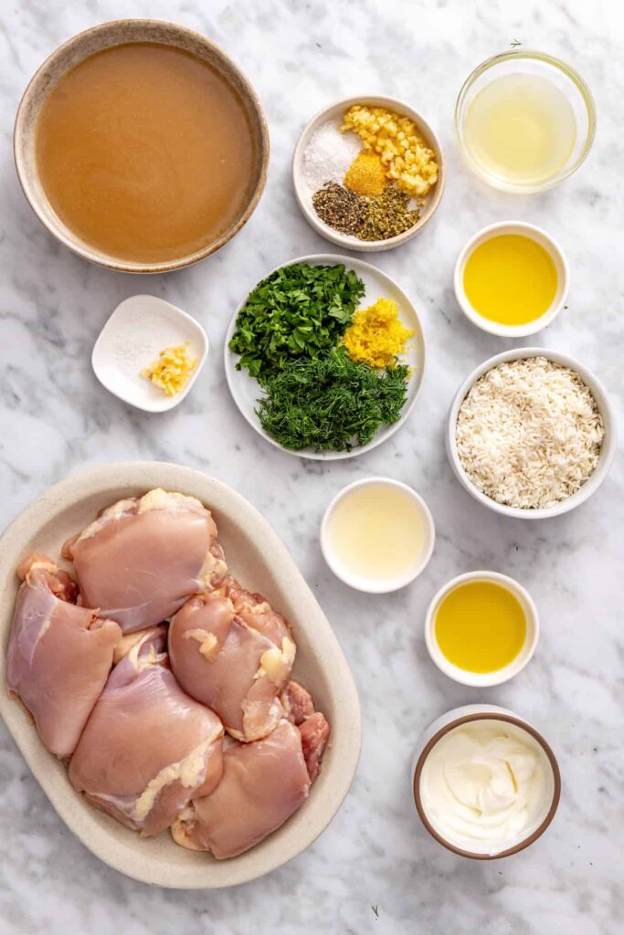 Ingredients for Instant Pot Greek lemon chicken and rice, including chicken thighs, white rice, chicken broth, fresh lemon, garlic, dill, parsley, and Greek yogurt.