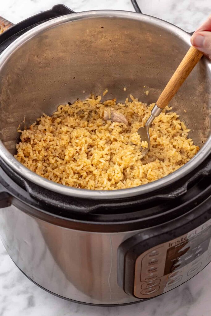 Cooked lemon rice fluffed with a fork and tossed with fresh dill, parsley, and lemon juice.