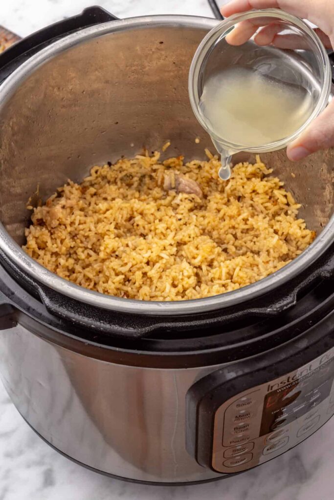 adding lemon juice to the cooked rice in the Instant Pot, for Greek Lemon Chicken and rice meal