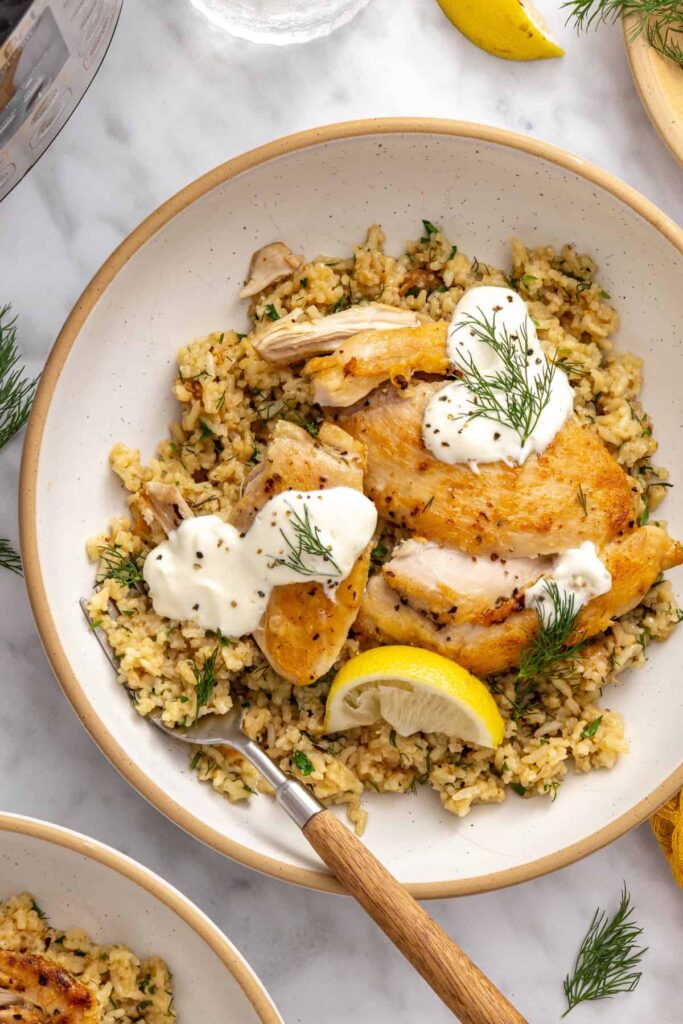 Greek lemon chicken and rice topped with fresh parsley, dill, and a tangy lemon yogurt sauce.