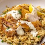 Instant Pot Greek lemon chicken and rice topped with creamy lemon yogurt sauce and fresh herbs.