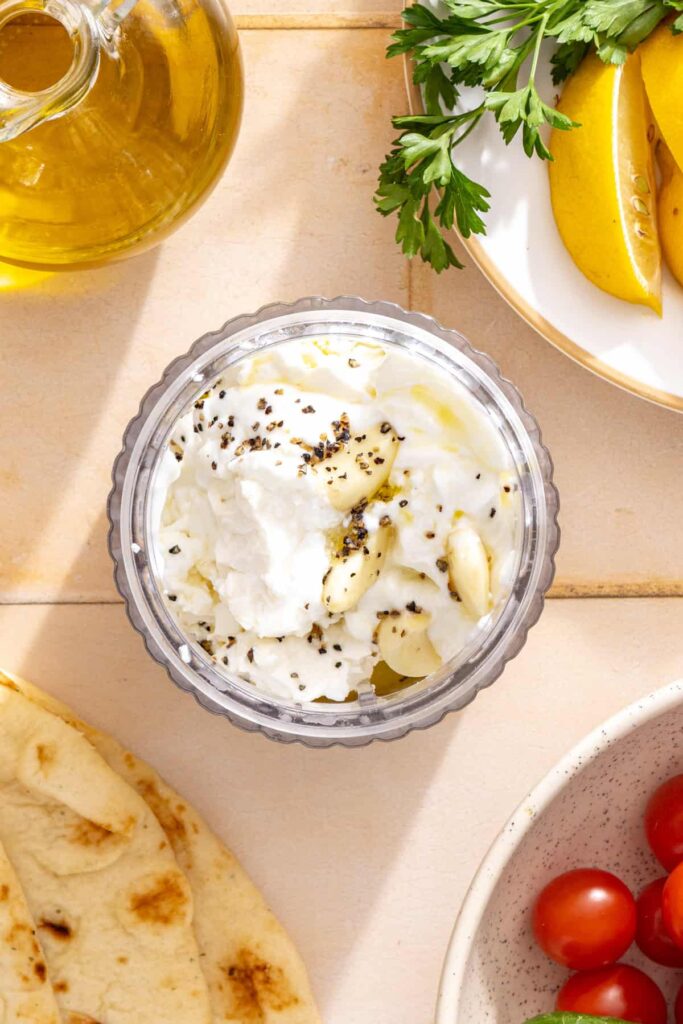 Block feta, Greek yogurt, garlic, lemon juice, olive oil, and water in a blender for creamy feta garlic sauce.