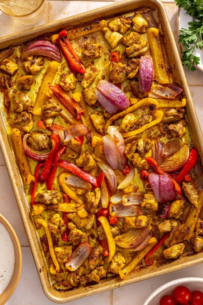 Fresh lemon juice squeezed over roasted chicken shawarma, bell peppers, and red onion straight from the oven.