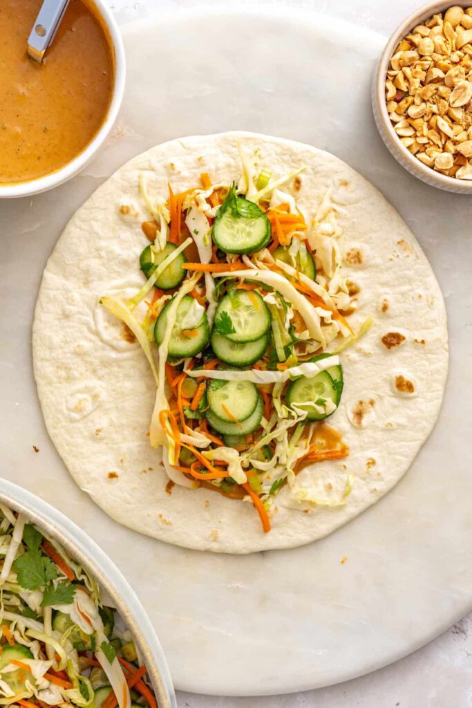 Crunchy cabbage, carrot, cucumber, and herb slaw layered over peanut sauce on a tortilla.