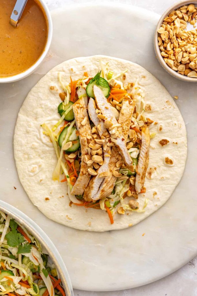Chopped roasted peanuts sprinkled over the chicken and crunchy slaw filling in a Thai peanut wrap.