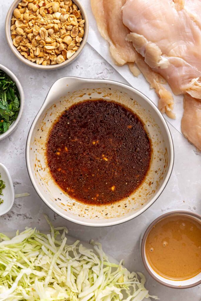 chicken marinade prepared in a bowl for healthy thai peanut chicken wraps